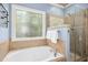 Elegant bathroom featuring a soaking tub, a glass-enclosed shower, and natural light at 1503 Anterra Dr, Wake Forest, NC 27587
