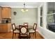 Bright dining area featuring hardwood floors, windows, and adjacent kitchen with wood cabinets at 1503 Anterra Dr, Wake Forest, NC 27587