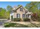 Brick and vinyl siding home with black shutters, lush landscaping, and an attached garage at 1503 Anterra Dr, Wake Forest, NC 27587
