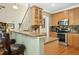 Open kitchen with wood cabinets, granite countertops, and stainless steel appliances offers a cozy breakfast bar at 1503 Anterra Dr, Wake Forest, NC 27587