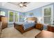 Serene main bedroom features a tray ceiling, carpet, and natural light from the large window at 1503 Anterra Dr, Wake Forest, NC 27587