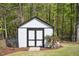 A well-maintained shed with black trim and matching double doors sits in the backyard at 1503 Anterra Dr, Wake Forest, NC 27587