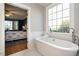Bright bathroom features a soaking tub, large window, and a view into the adjacent bedroom at 1545 Heritage Links Dr, Wake Forest, NC 27587