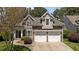 Charming stone and siding home boasts a manicured lawn and two-car garage at 1545 Heritage Links Dr, Wake Forest, NC 27587