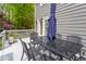 Back deck with a table, chairs, and umbrella, overlooking a scenic backyard at 1809 Green Ford Ln, Apex, NC 27502