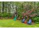 Spacious backyard with a playground, Adirondack chairs, and mature trees offering ample shade at 1809 Green Ford Ln, Apex, NC 27502