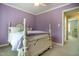 Bedroom with lavender walls, a queen bed, and white trim, showcasing the home's relaxing and inviting space at 1809 Green Ford Ln, Apex, NC 27502