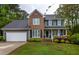 Charming two-story home with a brick and gray facade, lush landscaping, and a welcoming front porch at 1809 Green Ford Ln, Apex, NC 27502