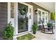Inviting front porch featuring a decorative wreath, potted plants, rocking chair and a green patterned door mat at 1809 Green Ford Ln, Apex, NC 27502