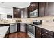 Stainless steel appliances and a center island with stone countertops and dark wood cabinets at 1919 Sinclair Trce, Burlington, NC 27215
