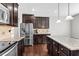 Spacious kitchen featuring stainless steel appliances, a center island and dark wood cabinets at 1919 Sinclair Trce, Burlington, NC 27215