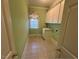 Laundry room featuring tile floors, utility sink, and storage cabinets at 208 E Jules Verne Way, Cary, NC 27511