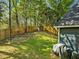 Spacious backyard with a wooden fence, mature trees, and a garden area, perfect for outdoor activities at 209 Dickens Dr, Raleigh, NC 27610
