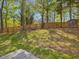 Expansive backyard with lush green grass, mature trees, and a wooden fence, creating a private oasis at 209 Dickens Dr, Raleigh, NC 27610