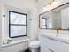 Bright bathroom featuring a black framed mirror, modern vanity, window, and gold fixtures at 209 Dickens Dr, Raleigh, NC 27610