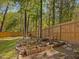 Charming garden area with raised planting beds, mature trees, and a cozy bench, perfect for gardening at 209 Dickens Dr, Raleigh, NC 27610