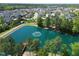 Scenic aerial view of a community with a tranquil lake, lush trees, and well-maintained homes under a sunny sky at 240 Liberty Star Rd, Wendell, NC 27591