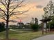 Scenic exterior view of a charming home, surrounded by green spaces and a tranquil pond at sunset at 240 Liberty Star Rd, Wendell, NC 27591