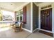 Charming front porch with rocking chairs, a decorative wreath, and stylish gray siding with contrasting shutters at 240 Liberty Star Rd, Wendell, NC 27591