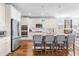 Open kitchen with white cabinets, a granite island with seating, pendant lights, and stainless steel appliances at 240 Liberty Star Rd, Wendell, NC 27591