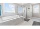 Luxurious main bathroom featuring a soaking tub, glass-enclosed shower, and marble accents at 240 Liberty Star Rd, Wendell, NC 27591