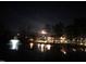 Night view of a pond with fountain, trees and building lights reflecting in the water at 240 Liberty Star Rd, Wendell, NC 27591