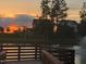 Scenic pond view with a community home in the background under a vibrant sunset sky at 240 Liberty Star Rd, Wendell, NC 27591