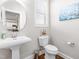 Tastefully decorated powder room with pedestal sink, toilet, and modern fixtures at 240 Liberty Star Rd, Wendell, NC 27591
