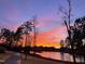 Scenic sunset view reflecting on a tranquil pond with trees and community houses in the background at 240 Liberty Star Rd, Wendell, NC 27591