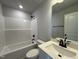 Modern bathroom featuring a tub and shower combination with elegant fixtures and bright lighting at 244 Bluejay St, Clayton, NC 27520