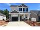 Charming two-story home featuring a gray and white color scheme, black shutters, and an attached garage at 244 Bluejay St, Clayton, NC 27520