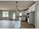 Bright kitchen featuring white cabinets, a granite island with pendant lighting, and stainless steel appliances at 244 Bluejay St, Clayton, NC 27520