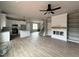 Open-concept living room with built in shelves, fire place, hard wood flooring and a ceiling fan at 244 Bluejay St, Clayton, NC 27520