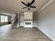 Open-concept living room with built in shelves, fire place, hard wood flooring and a ceiling fan at 244 Bluejay St, Clayton, NC 27520