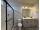 Bathroom with dual vanity sinks, a glass-enclosed shower, and tile flooring at 250 Bluejay St, Clayton, NC 27520