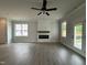Open living room with fireplace, ceiling fan, and luxury vinyl plank flooring at 250 Bluejay St, Clayton, NC 27520