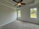 Main bedroom featuring a tray ceiling with a ceiling fan and two large windows at 250 Bluejay St, Clayton, NC 27520