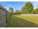 Fenced backyard with lush green grass and mature trees offering privacy at 28 Lee Woods Dr, Clayton, NC 27520
