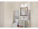 Charming half-bathroom with pedestal sink, decorative mirror, and wood-look flooring at 28 Lee Woods Dr, Clayton, NC 27520
