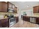 Modern kitchen featuring stainless steel appliances, granite countertops, and dark wood cabinets at 28 Lee Woods Dr, Clayton, NC 27520