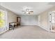Spacious living room with large windows, a ceiling fan, neutral walls and carpet, with french doors at 28 Lee Woods Dr, Clayton, NC 27520