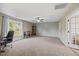 Spacious living room with large windows, a ceiling fan, and neutral walls and carpet at 28 Lee Woods Dr, Clayton, NC 27520