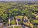 An aerial shot showcases the property's setting among mature trees and surrounding homes at 2804 Brenfield Dr, Raleigh, NC 27606