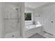 Bright bathroom featuring a soaking tub, marble surround and glass enclosed shower at 2804 Brenfield Dr, Raleigh, NC 27606