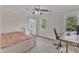 A bright bedroom with neutral tones features two windows, a ceiling fan, and carpet flooring at 2804 Brenfield Dr, Raleigh, NC 27606