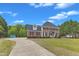 Classic two-story brick home with a long driveway and a well-maintained lawn at 2804 Brenfield Dr, Raleigh, NC 27606