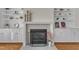 Elegant fireplace featuring marble surround, flanked by white built-in cabinets and shelves, perfect focal point at 2804 Brenfield Dr, Raleigh, NC 27606