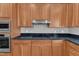 Bright kitchen showcases stainless steel appliances, granite counters, cherry wood cabinets and tiled backsplash at 2804 Brenfield Dr, Raleigh, NC 27606
