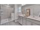 Beautiful bathroom with dual sinks, tile shower, and gray wood-look flooring at 3011 Ginger Hill Ln, Durham, NC 27703