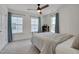 Bright bedroom featuring three windows, a ceiling fan, and neutral carpet at 3011 Ginger Hill Ln, Durham, NC 27703